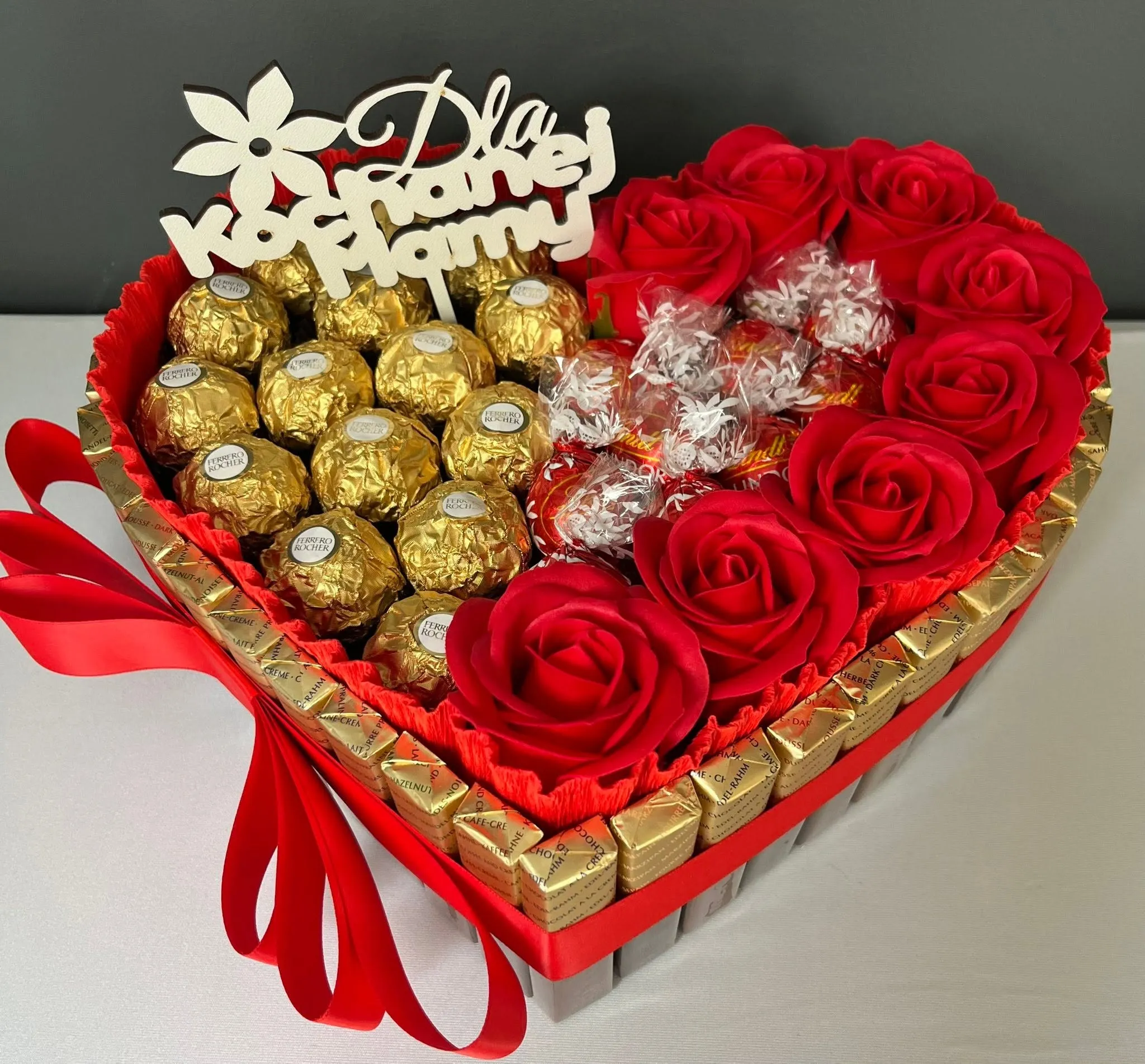 Kompozycja w kształcie serca z czerwonych róż i czekoladek Ferrero Rocher z napisem „Dla kochanej Mamy”